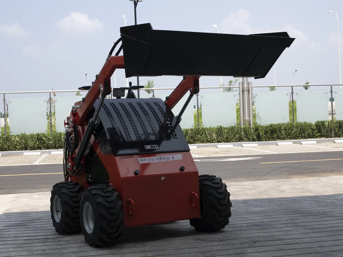 Red KORVA S460 wheel mini skid steer loader with bucket raised for loading